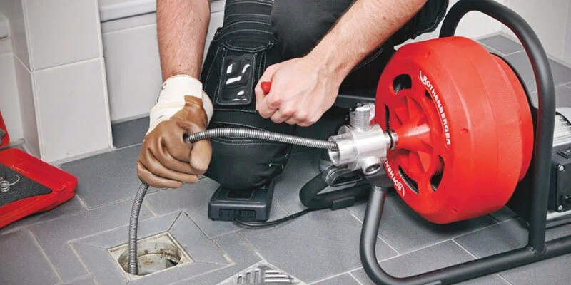 Plumber using a drain-cleaning machine in Punta Gorda