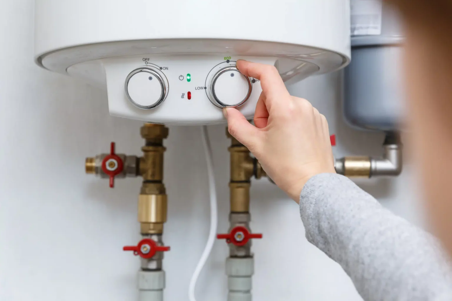 Homeowner adjusting the temperature controls on a water heater in Punta Gorda